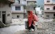 A woman salvages her belongings from her house heavily covered in mud following flash floods at Devighat in Nepals Nuwakot district on August 28, 2026. More than 1,400 people are missing and at least 552 have been killed after a devastating, tsunami-like wall of water gouged a path through the border region between Nepal and Tibet, sweeping away entire villages. (Photo by MANAN VATSYAYANA / AFP)