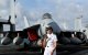 Una efectivo de la Armada estadounidense se encuentra junto a un avión en la cubierta del portaaviones USS George Washington.