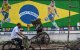 Un ciclista pasa junto a un grafiti con las imágenes del futbolista brasileño Neymar