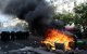 Agentes de policía custodian contenedores de basura y muebles incendiados en la calle durante una manifestación en París