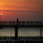 Un hombre solitario camina por un muelle