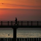 Un hombre solitario camina por un muelle