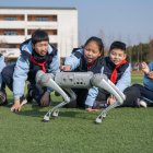 Los alumnos interactúan con un perro robot durante un descanso en clase en la escuela primaria Xinyi.