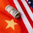 Chinese flag and USA flag with some dollars