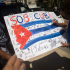 Una bandera cubana en la que puede leerse una llamada de auxilio