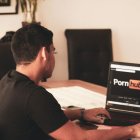 Joven consultando el sitio web de contenido para adultos Pornhub.