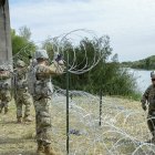 Militares de la Guardia Nacional en la frontera con México levantan una alambrada.