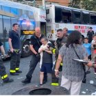 Captura de pantalla de los bomberos acompañando a un hombre con el brazo izquierdo lesionado. Detrás se pueden ver dos autobuses colisionados.
