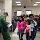 Several immigrants are assisted by members of the Border Patrol to enter the country.
