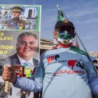 Un manifestante lleva un cartel de apoyo a Reza Pahlavi con su fotografía.