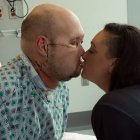 In this undated image released by NYU Langone Health, Aaron James (L) kisses his wife Meagan while he recovers from the first whole-eye and partial face transplante, at NY Langone Health in New York. A team of surgeons in New York has performed the world's first transplant of an entire eye in a procedure described as a medical breakthrough, though it isn't yet known whether the patient will regain their sight. The groundbreaking surgery involved removing part of the face and the whole left eye of a donor and grafting them onto James, a 46-year-old lineworker who survived a 7,200-volt electric shock in June 2021 when his face touched a live wire. (Photo by Handout / NYU Langone Health / AFP)