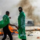 Fotografía de unos manifestantes con la bandera de Hamás, quemando neumáticos.