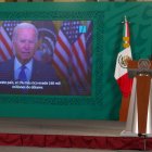 El presidente de México habla con una imagen de Joe Biden de fondo.