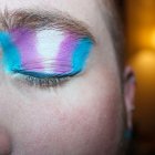 Ojo cerrado con una sombra de maquillaje representando la bandera Trans.