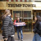 Un simpatizante de Donald Trump con un cartel de apoyo al expresidente en las puertas de la Torre Trump de Nueva York.