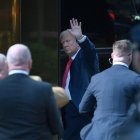 Trump waves upon his arrival at the Tower that bears his name in New York.