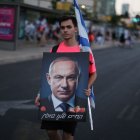 Un manifestante israelí posa con un retrato de Benjamin Netanyahu.