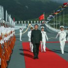 Xi Jinping camina al lado de miembros de las fuerzas armadas antes de abordar el portaviones Shandong.