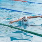 Deportista en una piscina nadando mariposa.