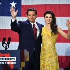 Ron DeSantis junto a su mujer en un atril frente a la bandera Norteamericana.