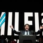 El candidato presidencial argentino Javier Milei habla en un estrado delante de una gigantografía con su nombre y el año 2023.