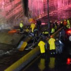 Rescuers search for people trapped under a wall that collapsed on several vehicles after heavy rains on 27 de Febrero Avenue in Santo Domingo on November 18, 2023 in República Dominicana.
