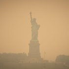 Imagen de la Estatua de la Libertad, en Nueva York, teñida de naranja a consecuencia de la nube tóxica proveniente de Canadá.