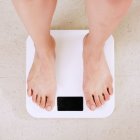 Persona pesándose para controlar su peso.