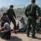 Una familia intentando ingresar a Estados Unidos rompe el alambrado de púas.