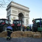 Policías observan tractores aparcados junto al Arco del Triunfo en la avenida de los Campos Elíseos durante una protesta del sindicato de agricultores franceses en París el 1 de marzo de 2024.