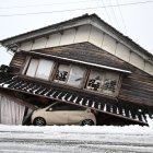 Un coche dañado yace bajo un edificio derrumbado en la ciudad de Shika, en el distrito de Hakui, prefectura de Ishikawa, el 8 de enero de 2024.