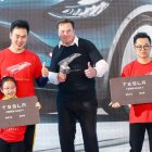El consejero delegado de Tesla, Elon Musk (C), posa para las fotos con los compradores durante la ceremonia de entrega del Modelo 3 fabricado en China por Tesla en Shanghái.
