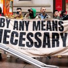 Un manifestante sostiene una pancarta que dice "Por todos los medios necesarios" en una manifestación de apoyo a Palestina / Gaza en el Parque Zuccotti de Nueva York.