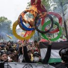 A protester hold up a burning Olympic five ring over his head during the demonstration in Paris, France.