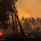 (240812) -- ATHENS, Aug. 12, 2024 (Xinhua) -- A car (lower left corner) catches fire during a wildfire in Varnavas, around 35 km from Athens, Greece, on Aug. 11, 2024. Greek firefighters were battling a major wildfire for several hours on Sunday near Athens, which has forced the evacuation of five settlements, the Fire Brigade said.