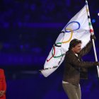 El actor estadounidense Tom Cruise sale con la bandera olímpica ante la alcaldesa de Los Ángeles, Karen Bass