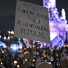 Un manifestante sostiene un cartel contra la reforma judicial de AMLO