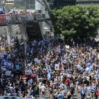 Familiares y simpatizantes de los rehenes israelíes retenidos por terroristas palestinos en la Franja de Gaza desde octubre levantan pancartas y corean consignas pidiendo su liberación durante una concentración en Tel Aviv el 2 de septiembre de 2024