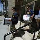 Agentes del FBI retiran cajas de documentos de las oficinas del California Investment Immigration Fund tras presentar órdenes de registro en el marco de una investigación sobre una presunta trama de fraude de visados de alta gama por valor de 50 millones de dólares en la que están implicados hasta 100 ciudadanos chinos en San Gabriel, California, el 5 de abril de 2017.