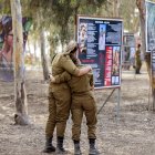 Guerra en Israel: Soldadas del ejército israelí se abrazan mientras visitan un monumento en memoria de las víctimas asesinadas o secuestradas en el festival de música Supernova