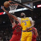 nba: El alero de Los Angeles Lakers Anthony Davis (3) recibe una falta del alero de Toronto Raptors Chris Boucher (25) mientras va a encestar durante la primera mitad en el Scotiabank Arena.