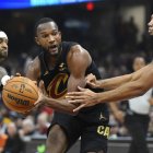 El alero de los Cleveland Cavaliers Evan Mobley (4) regatea entre el escolta de los Golden State Warriors Gary Payton II (0) y el alero Trayce Jackson-Davis (32) en el primer cuarto en el Rocket Mortgage FieldHouse.