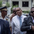 Oficiales de seguridad armados escoltan al entonces primer ministro haitiano Garry Conille mientras visita el Hospital General en Puerto Príncipe