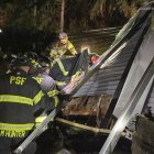 Bomberos asistiendo un trailer donde cayó un árbol durante una bomba ciclónica.