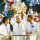 El entrenador Neale Fraser levanta el trofeo con los jugadores mirando