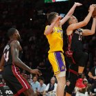 El alero de los Miami Heat Duncan Robinson (55) conduce hacia la canasta mientras el escolta de Los Angeles Lakers Dalton Knecht (4) defiende en la primera mitad en el Kaseya Center.