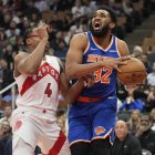 El pívot de los New York Knicks Karl-Anthony Towns (32) conduce contra el alero de los Toronto Raptors Scottie Barnes (4) durante la primera mitad en el Scotiabank Arena.