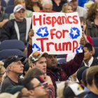 Un hombre sostiene un cartel en el que se lee "Hispanos por Trump"