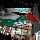 Activists fly a Palestinian flag as they demonstrate during the New York Times DealBook Summit on November 29, 2023. AFP