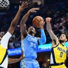 El escolta de los Indiana Pacers Tyrese Haliburton (0) bloquea el tiro del alero de los Cleveland Cavaliers Isaac Okoro (35) mientras el pívot Myles Turner (33) también defiende durante la primera mitad en el Rocket Mortgage FieldHouse.